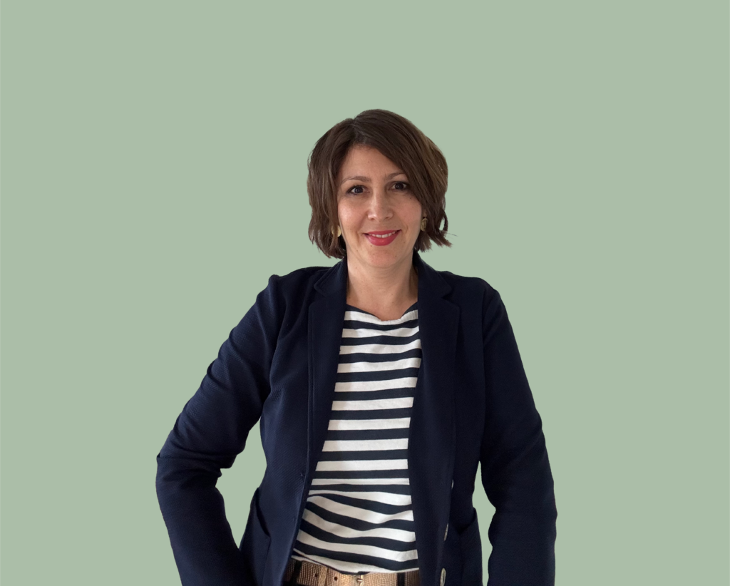 Christine Orth mit lachendem Gesicht und grünem Hintergrund